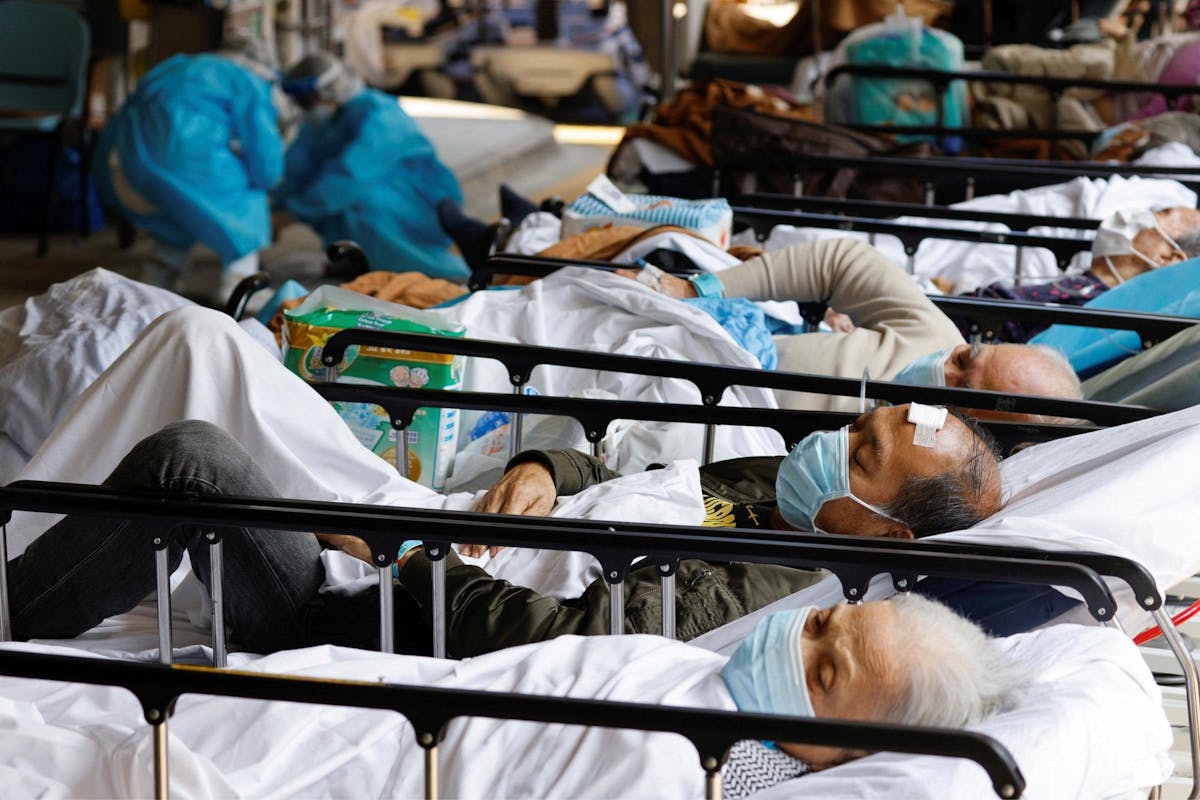 Des patients portant des masques se reposent dans une zone de traitement de fortune à l'extérieur d'un hôpital, suite à l'épidémie de coronavirus à Hong Kong, en Chine, le 2 mars 2022.