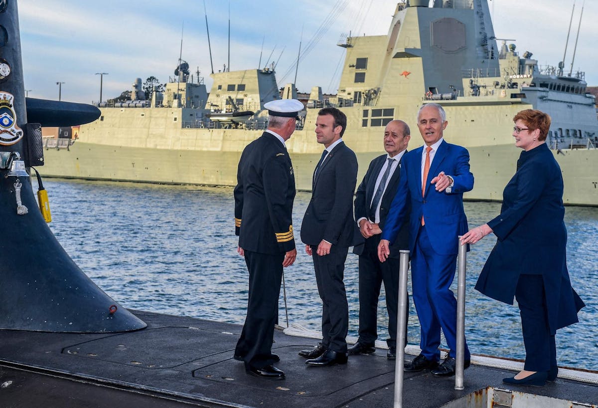 En mai 2018, le président Emmanuel Macron était ici avec le Premier ministre australien Malcolm Turnbull (2e à droite) et son ministre de la Défense Jean-Yves Le Drian sur un sous-marin de la Marine australienne dans la baie de Sydney.