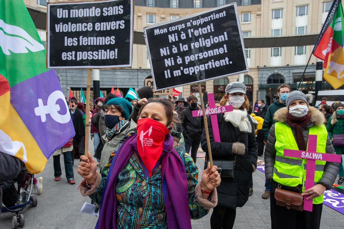 Une femme tient des pancartes, lors d’une manifestation convoquée par l’association Mirabal Belgium, contre les violences faites aux femmes, le 22 novembre 2020 à Bruxelles.
