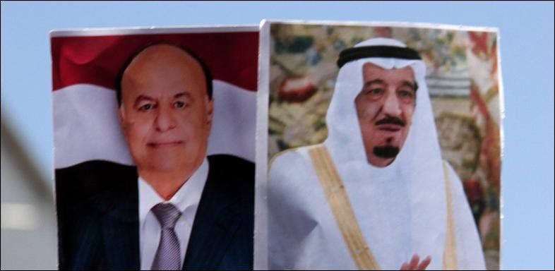 Ein Unterstützer des Präsidenten Hadi hält bei einer Demonstration dessen Porträt und eines des saudischen Königs Salman ibn Abd al-Aziz Al Saud in die Höhe.