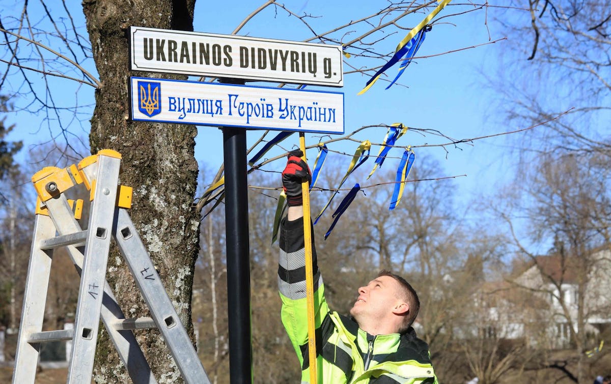 Un employé municipal de Vilnius fixe les panneaux de la rue des Héros-Ukrainiens en lituanien et en ukrainien.