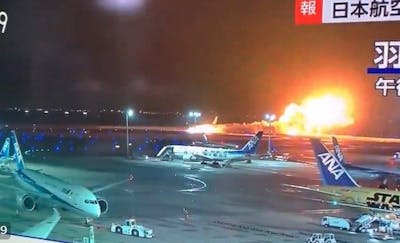 Un avion de ligne en feu sur la piste de l'aéroport de Tokyo
